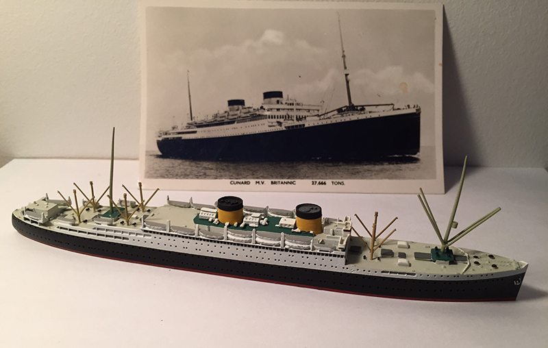 Miniature model of the ship Britannic next to a postcard of the ship.