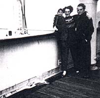 Photo of man, woman and small child on deck of ship.