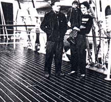 Photo of man, woman and small child on deck of ship.