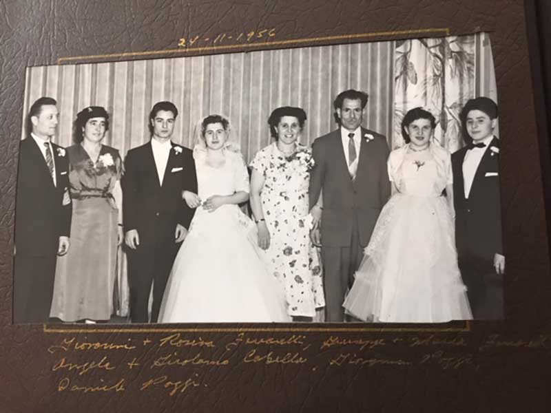 Wedding photo with bride and groom surrounded by three couples.