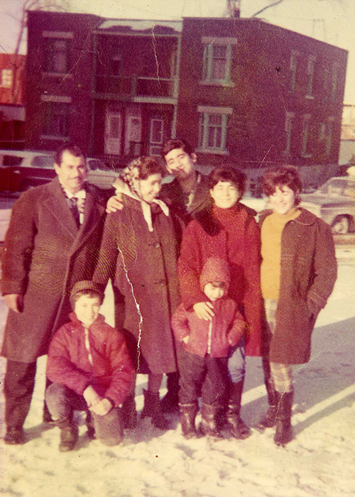 Seven family members standing on snowy street.