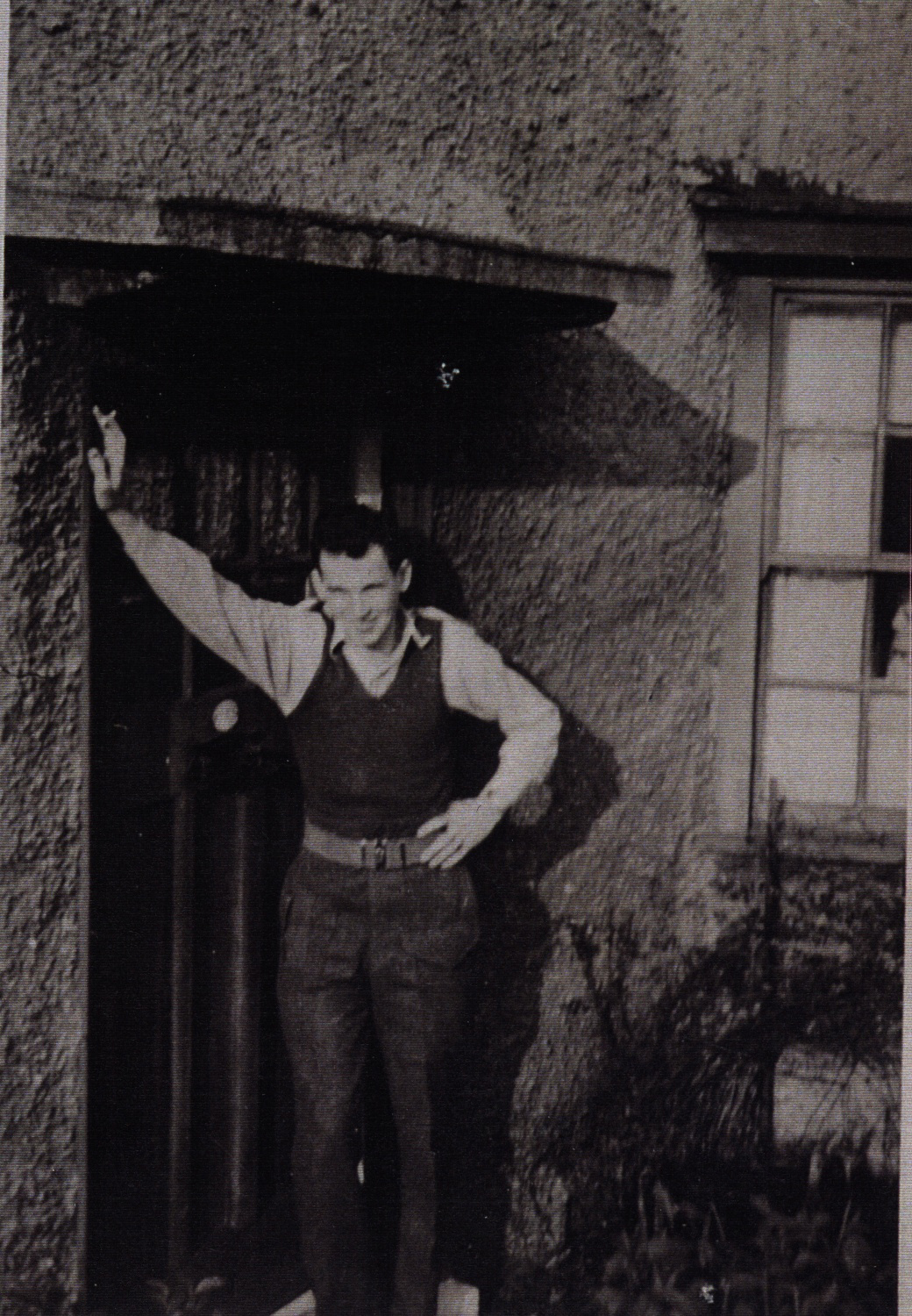 Man standing with arm leaning against doorway.