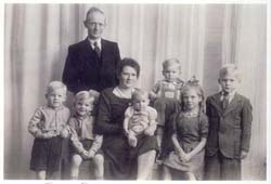 Old family photograph with mother, father and six children. 