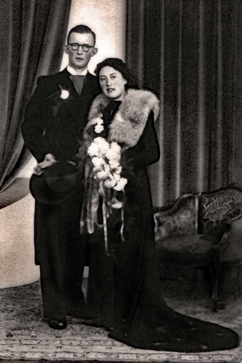 A man and woman stand in beautiful clothing on their wedding day.