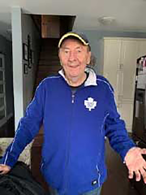 Older man wearing a baseball cap and blue Maple Leafs jacket.