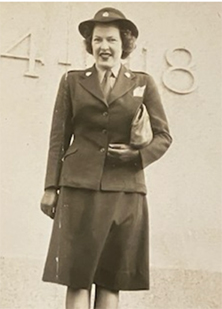 Sepia photo of a smiling white woman dressed in uniform.