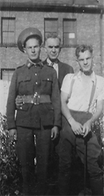 Black and white photo of three standing men, one of which is in uniform. 